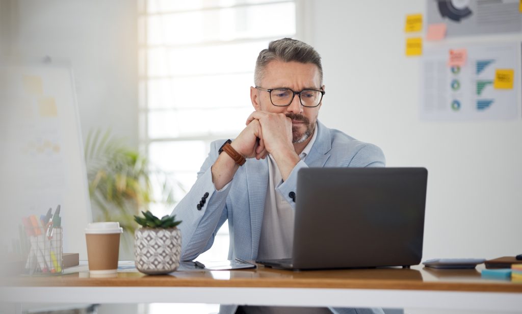 Laptop, thinking and error with a business man in the office for problem solving an issue as a manager. Computer, 404 and confused with a corporate employee in doubt about an idea, report or info.